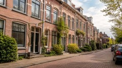 Karakteristieke Rotterdamse woningen in een rustige straat als beeld bij uitleg over funderingsrisico in het taxatierapport bij aankoop en verkoop van een huis.