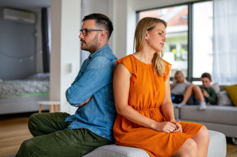 Stel pijnzend op bank kinderen op achtergrond scheiding en woningmarkt Makelaar Rotterdam expert bij scheidingen