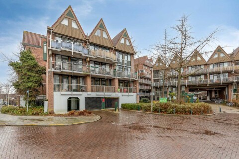 Wooncomplex Hofdijk aan het Stroveer in Rotterdam, ontworpen door architect Jan Verhoeven in 1977, met donkerrode bakstenen, schuine kappen, verspringende balkons en een herkenbaar jaren &rsquo;70 structuralistisch daklandschap.